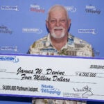 James Devine stands with his $4 million Platinum Jackpot check