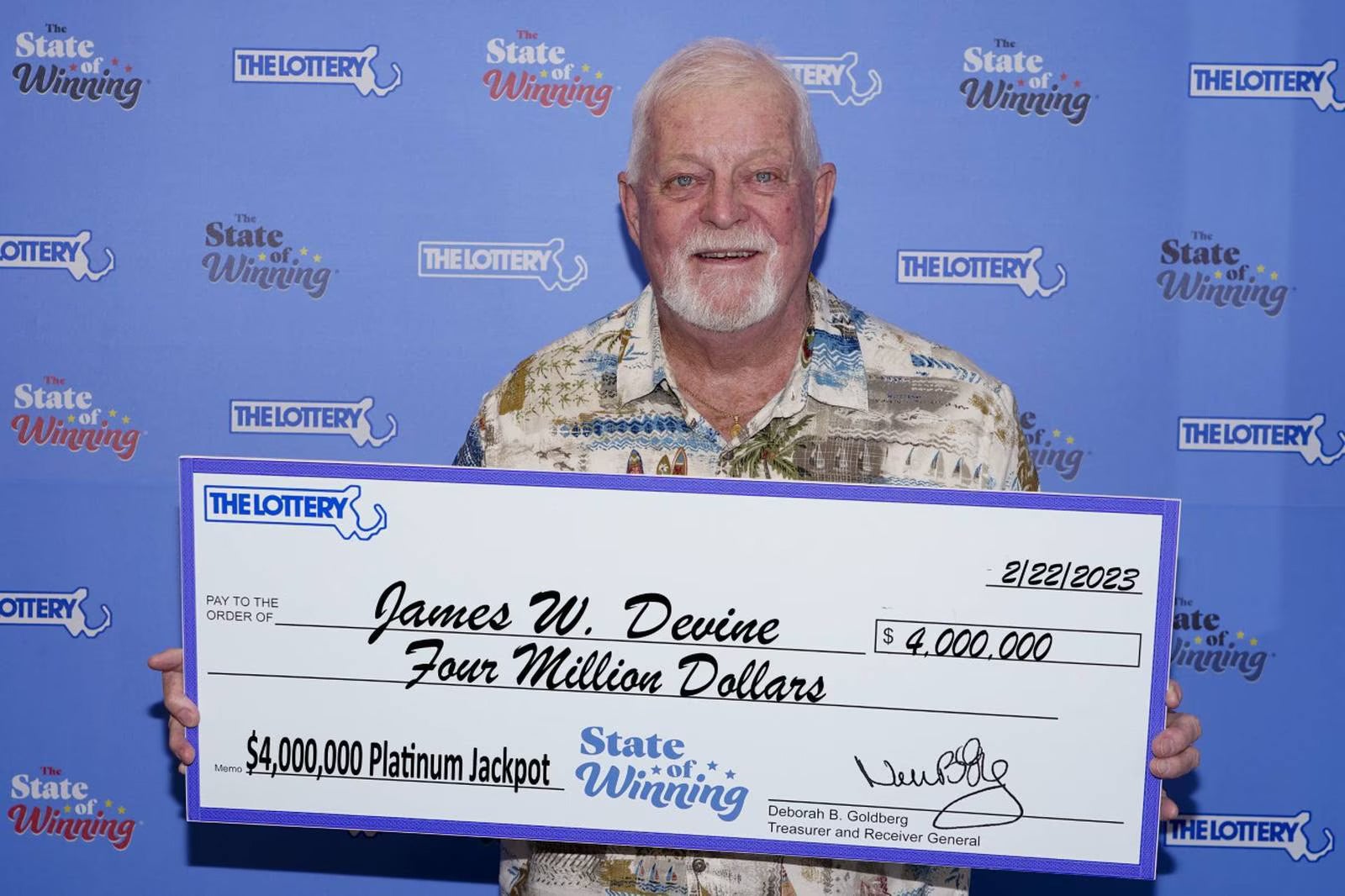 James Devine stands with his $4 million Platinum Jackpot check