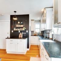 The kitchen has ample counter space, hardwood floors and white Shaker-style cabinets.
