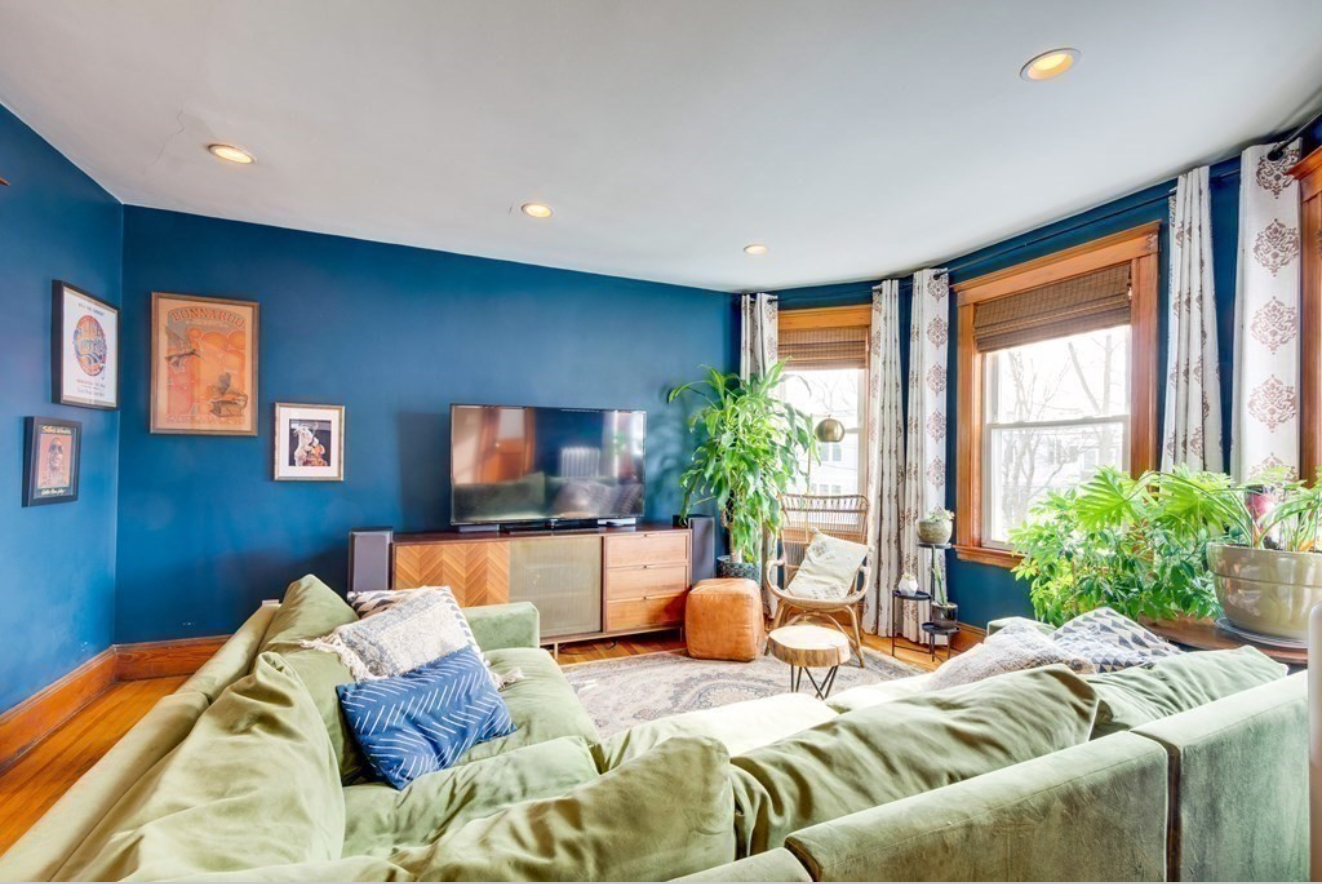 The living room is painted capri blue and has a bay window. 