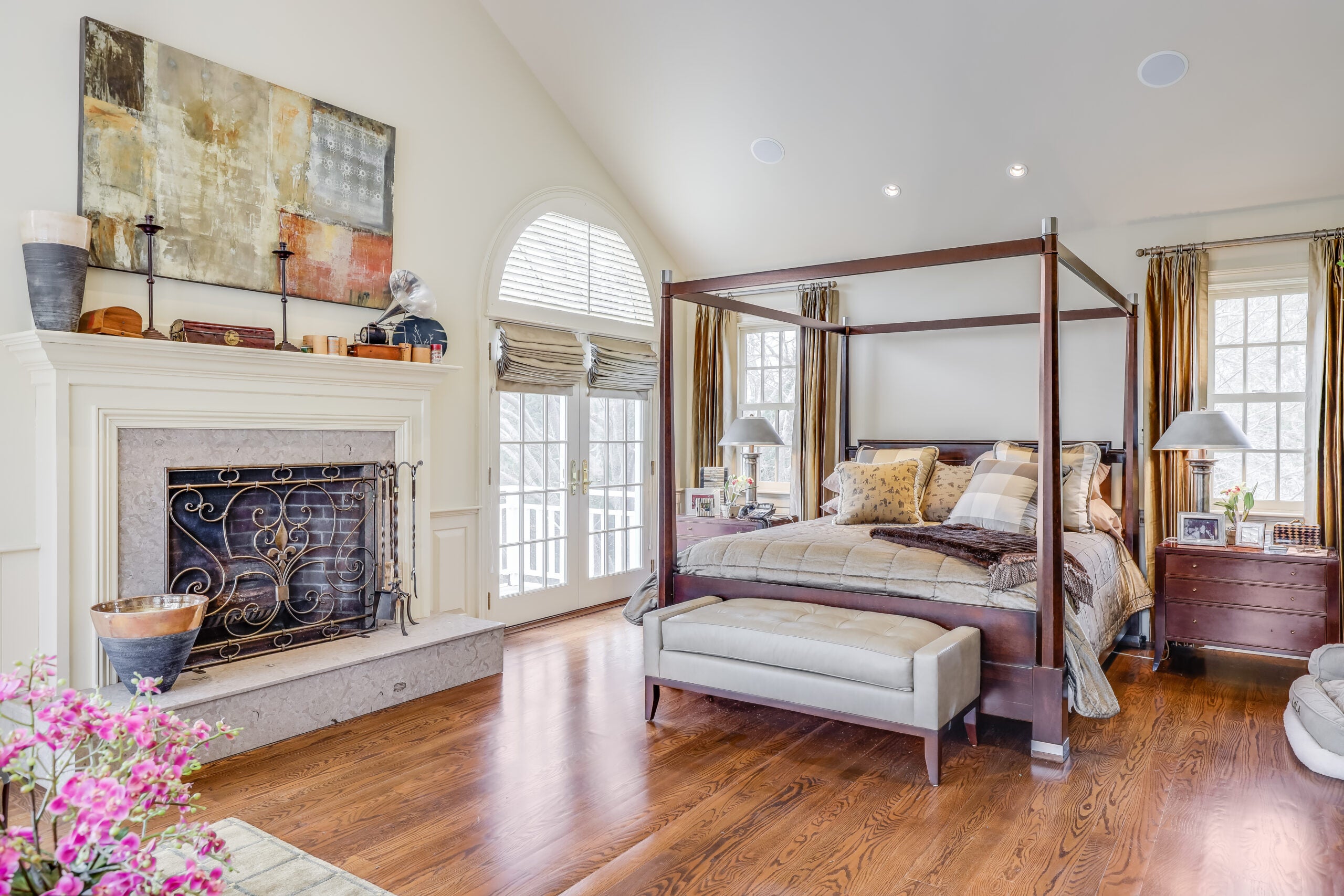 The primary bedroom has cream-colored walls, hardwood floors, and a fireplace.