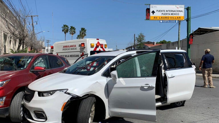 A member of the Mexican security forces stands next to a white minivan with North Carolina plates and several bullet holes, at the crime scene where gunmen kidnapped four U.S. citizens who crossed into Mexico from Texas, Friday, March 3.