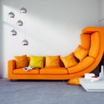 An orange sofa is squished up a wall to illustrate apartment size.
