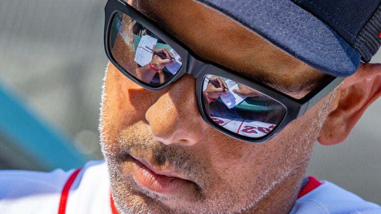 Sox manager Alex Cora fills out changes in his lineup card during a spring training game.