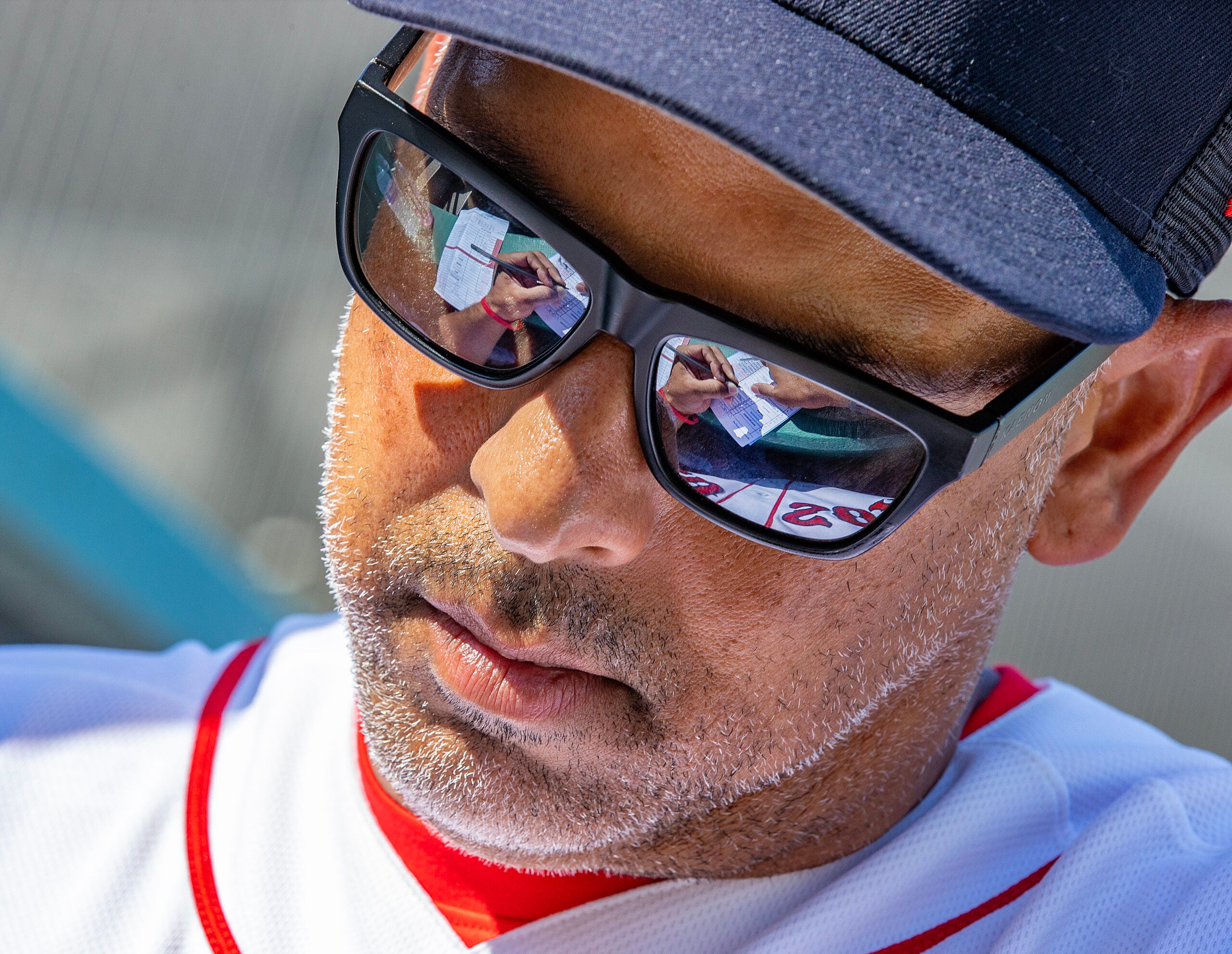 Sox manager Alex Cora fills out changes in his lineup card during a spring training game.