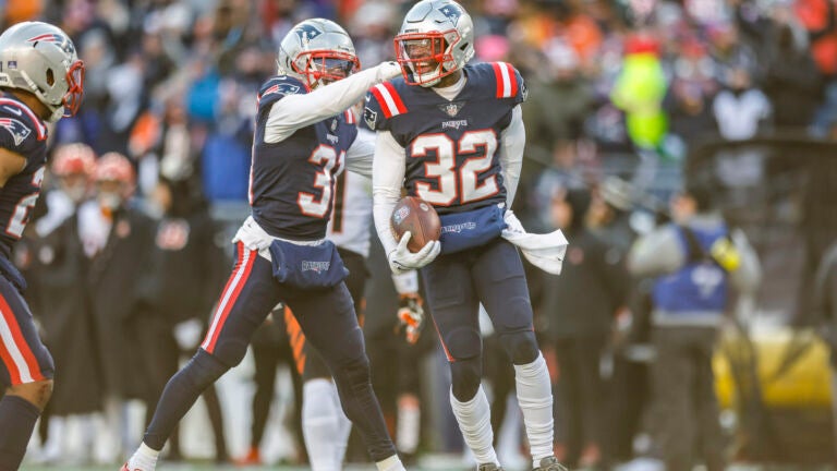 New England Patriots safety Devin McCourty (32) celebrates with cornerback Jonathan Jones (31) after an interception during the first half of an NFL football game against the Cincinnati Bengals, Saturday, Dec. 24, 2022, in Foxborough, Mass.