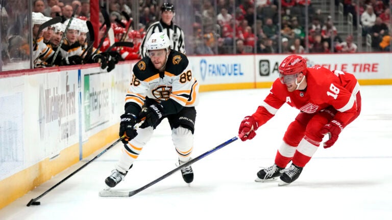 Detroit Red Wings center Andrew Copp (18) defends Boston Bruins right wing David Pastrnak (88) in the second period of an NHL hockey game Sunday, March 12, 2023, in Detroit.