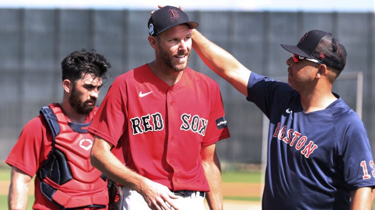 Red Sox pitcher Chris Sale (center) threw a live batting practice session as he continues to work back from his injuries. After he was done he got a pat on the head from manager Alex Cora (right). Connor Wong, who caught the session is at left.