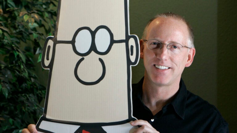 Cartoonist Scott Adams with a cardboard cutout of his character Dilbert