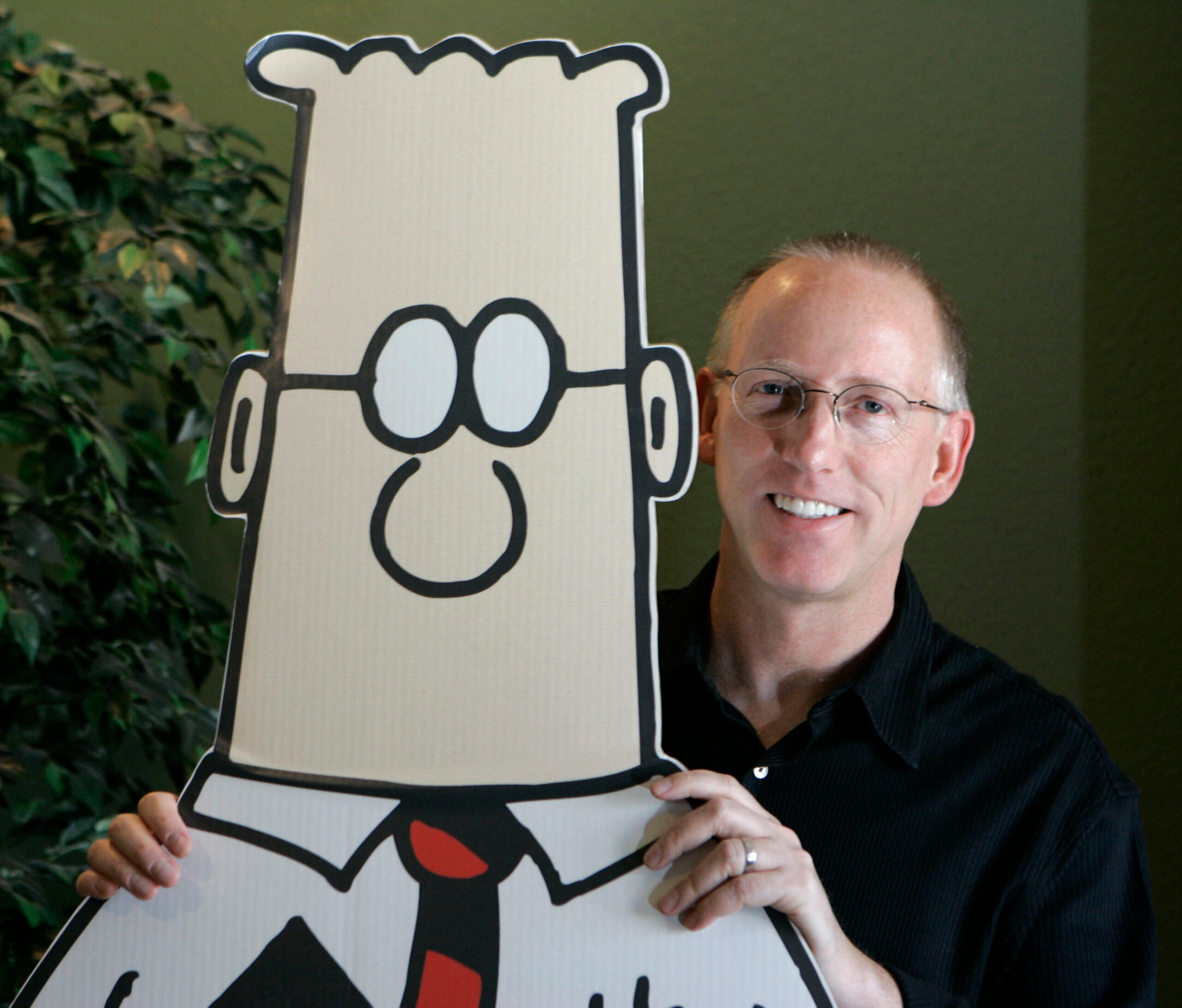 Cartoonist Scott Adams with a cardboard cutout of his character Dilbert