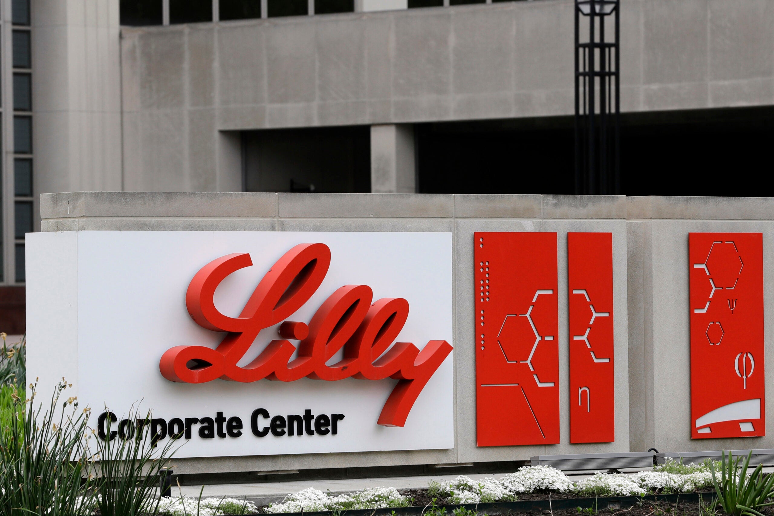 The Eli Lilly & Co. corporate headquarters in Indianapolis. Concrete building with red and black lettering on a white sign.