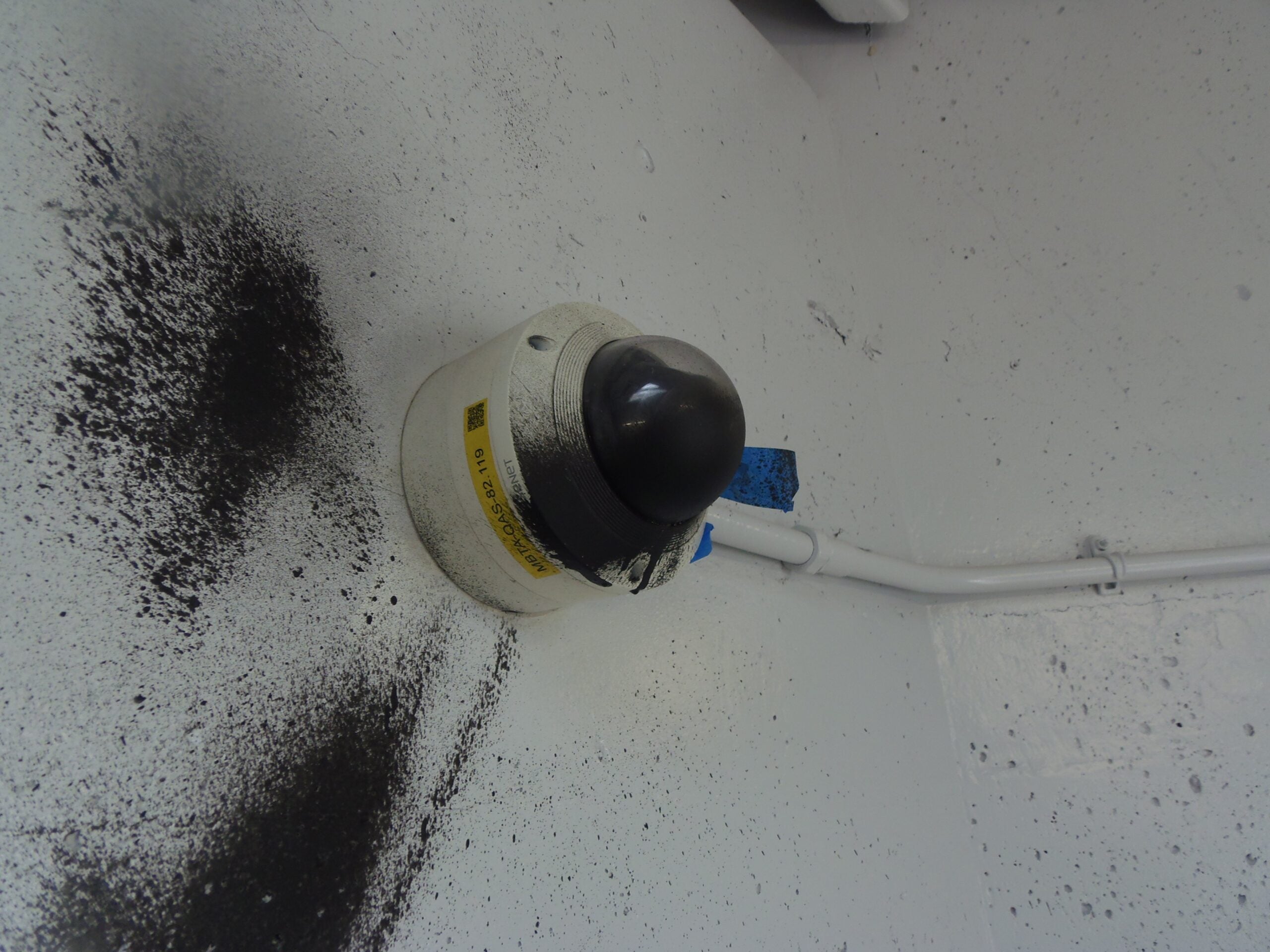 alt = an MBTA security camera vandalized with black spray paint