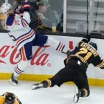 Oilers defenseman Darnell Nurse (25) and Boston Bruins right wing Garnet Hathaway (21) slam into the boards after colliding during the second period