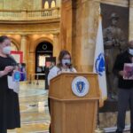 From left: Jennifer Ritz Sullivan, Megan Hale, and Desire James at a press conference calling for the creation of a COVID-19 Day Remembrance Day. Ritz Sullivan holds a photo of Paula, Hale's mother who died from COVID. James holds a photo of his mother, Florcie, who also died of the virus.