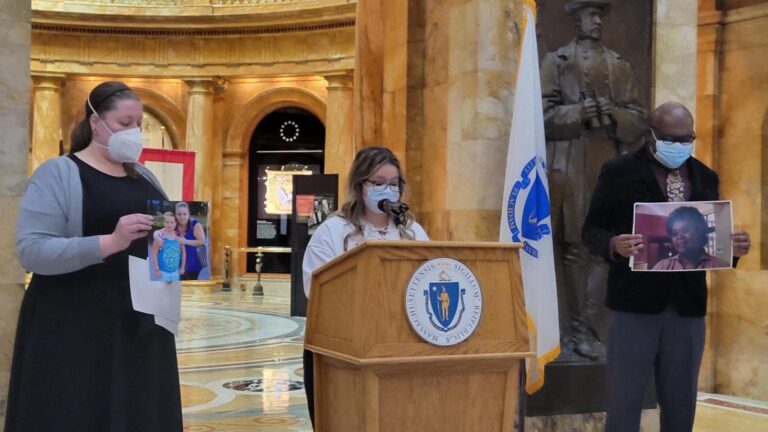 From left: Jennifer Ritz Sullivan, Megan Hale, and Desire James at a press conference calling for the creation of a COVID-19 Day Remembrance Day. Ritz Sullivan holds a photo of Paula, Hale's mother who died from COVID. James holds a photo of his mother, Florcie, who also died of the virus.