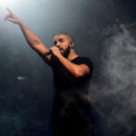 Drake points to the audience while performing onstage in London.