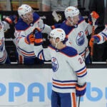 Oilers defenseman Evan Bouchard celebrates with teammates