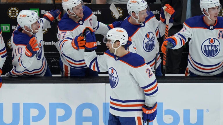 Oilers defenseman Evan Bouchard celebrates with teammates