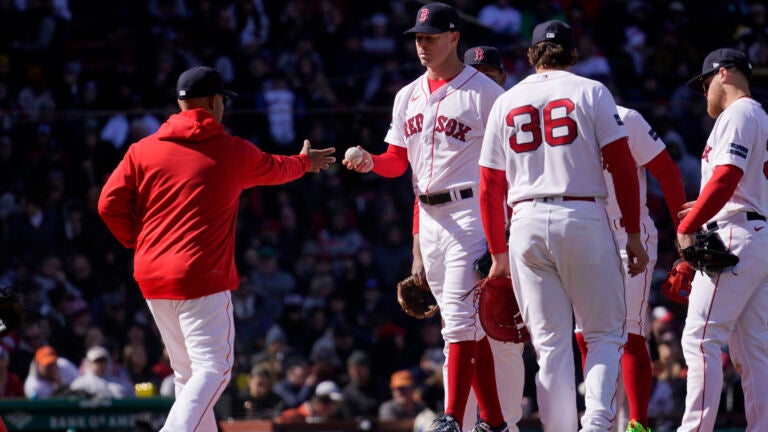 Boston Red Sox manager Alex Cora, left, takes the ball from starting pitcher Corey Kluber during the fourth inning of an opening day baseball game against the Baltimore Orioles, Thursday, March 30, 2023, in Boston.
