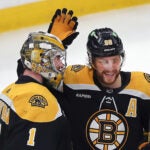 Boston Bruins right wing David Pastrnak congratulates Boston Bruins goaltender Jeremy Swayman (1) at the end of the game.
