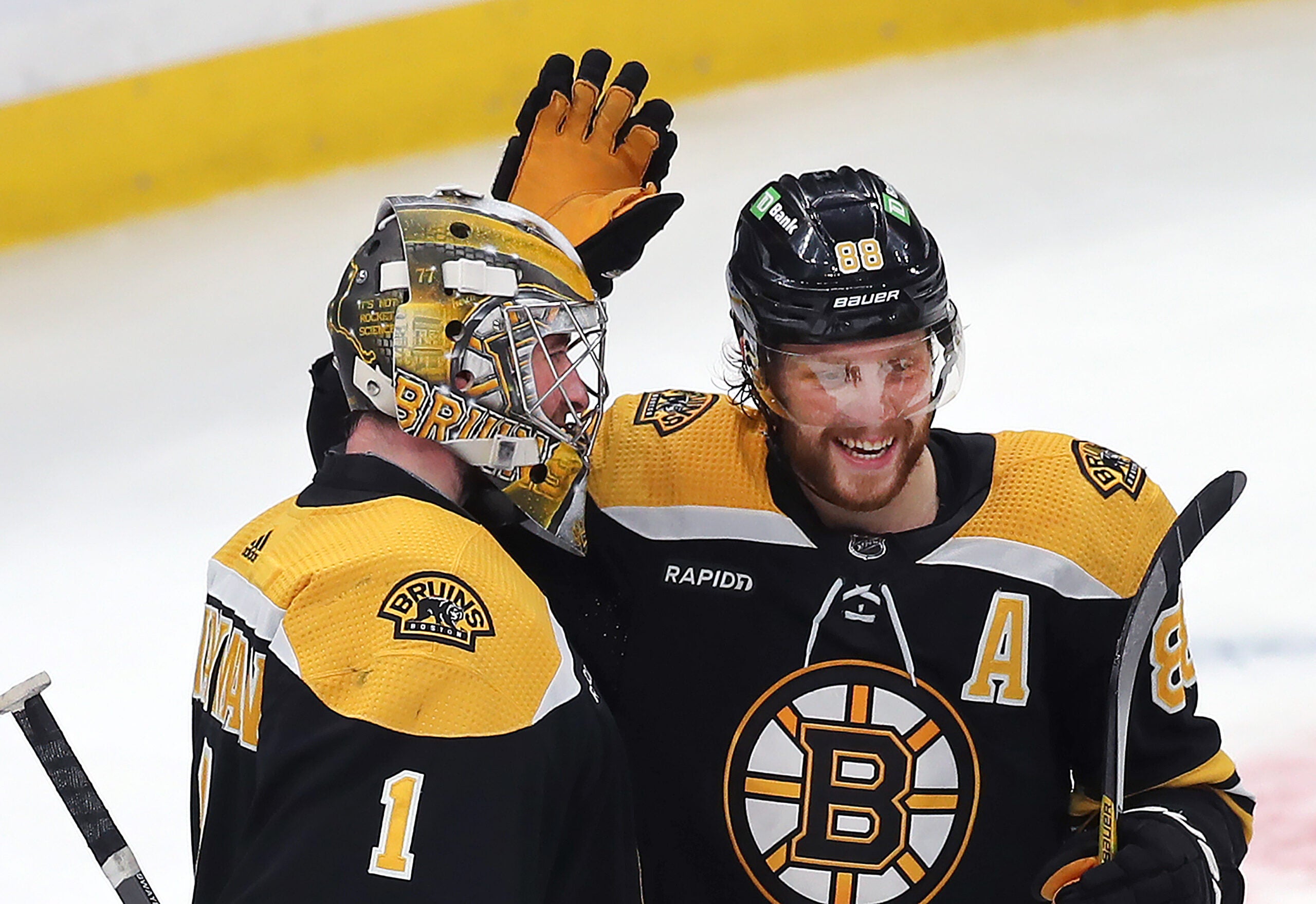 Boston Bruins right wing David Pastrnak congratulates Boston Bruins goaltender Jeremy Swayman (1) at the end of the game.