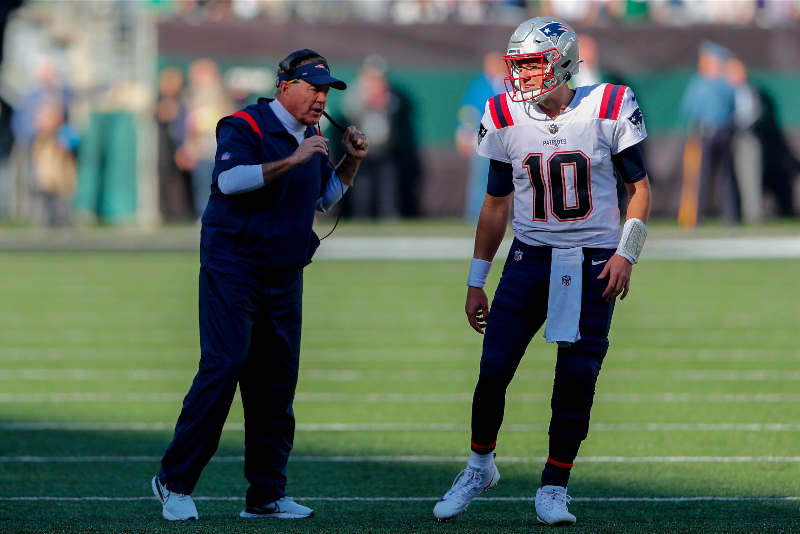 New England Patriots head coach Bill Belichick talks with quarterback Mac Jones (10) during the second quarter of an NFL football game, Sunday, Oct. 30, 2022, in New York.