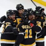 Boston Bruins' Charlie Coyle (13) celebrates his goal with teammates during the first period of an NHL hockey game against the New York Rangers, Saturday, March 4, 2023, in Boston.