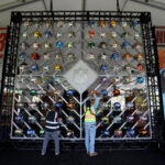 Workers install a helmet display in the Gallery Pavilion on the south lawn of The National WWI Museum and Memorial in Kansas City, Mo., Tuesday, April 25, 2023, in preparation for the NFL Draft.