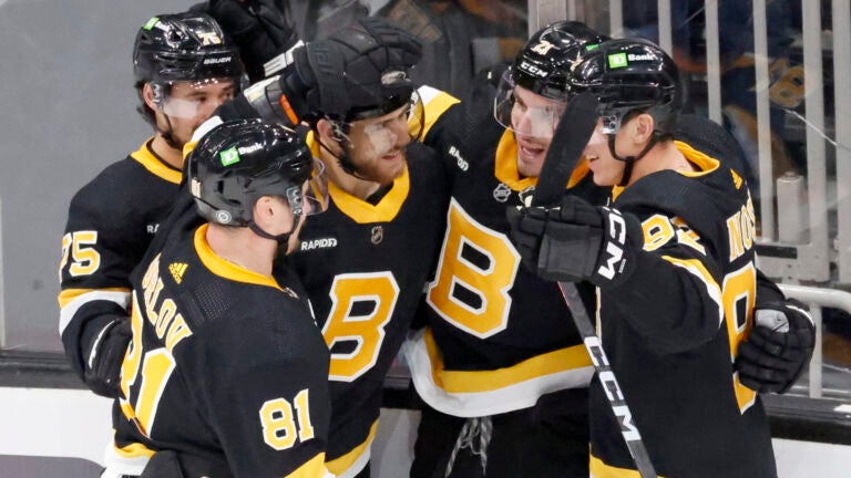 Boston Bruins players congratulate teammate Garnet Hathaway (21) after he scored the game-winning goal against the Detroit Red Wings during the third period of an NHL hockey game, Saturday, March 11, 2023, in Boston.