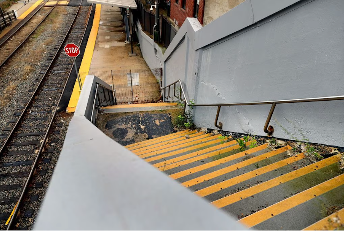 The crumbling concrete staircase at Milton Station was blocked by a fence and concrete Jersey barrier in 2021.
