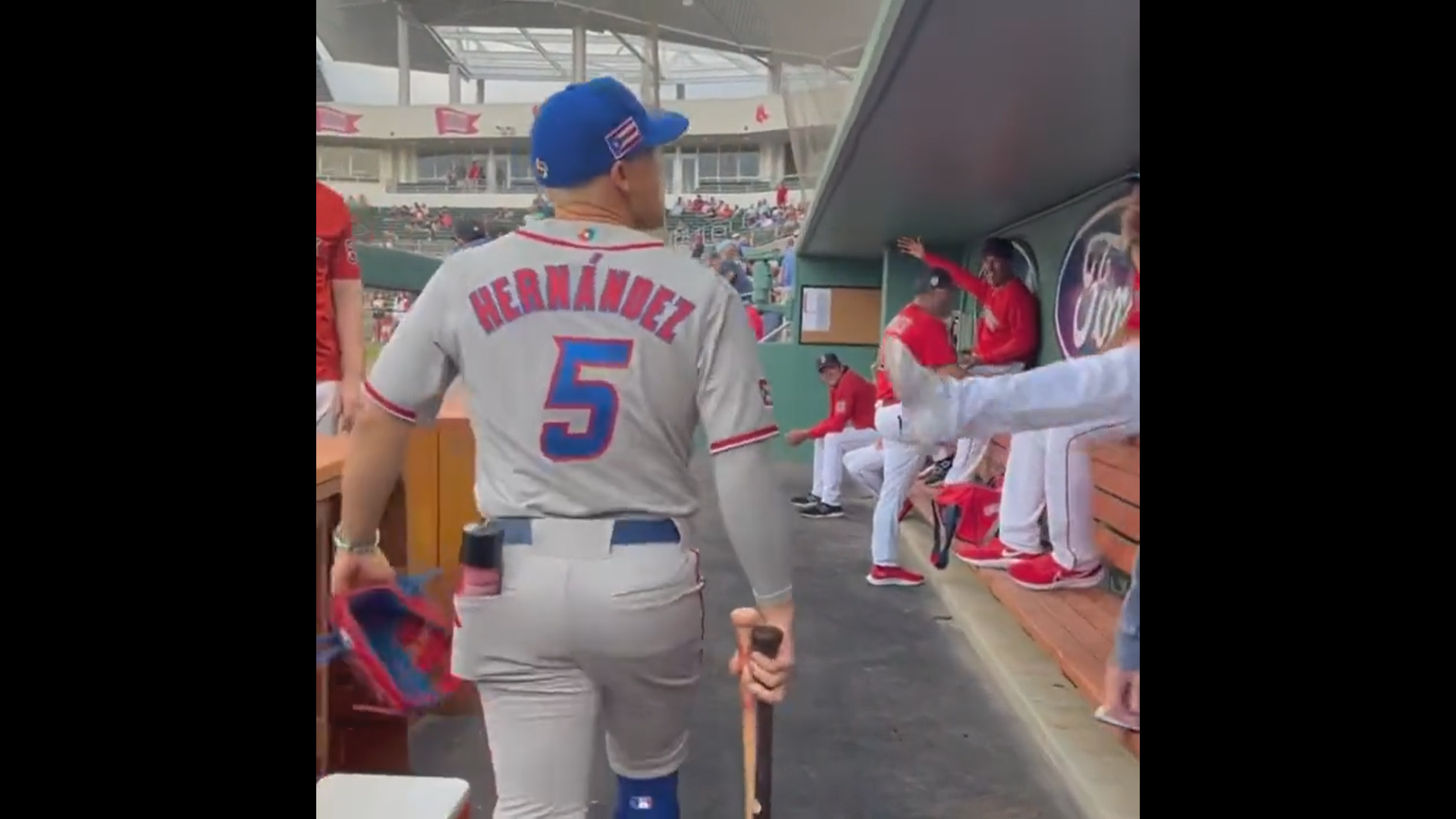 Kike Hernandez walking through the Red Sox dugout in his Puerto Rico uniform.