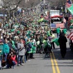 Spectators partially fill a street during a portion of the annual St. Patrick's Day parade in Boston, 2019.