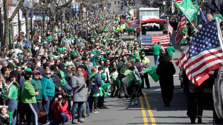 Spectators partially fill a street during a portion of the annual St. Patrick's Day parade in Boston, 2019.