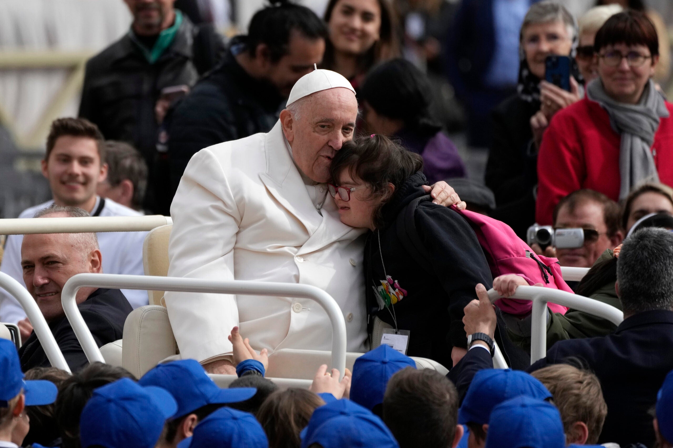 Pope Francis hugs a child .