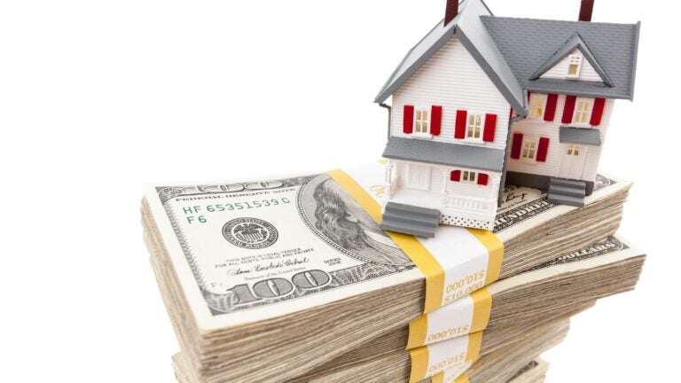 A home sits on a pile of money to represent home equity.