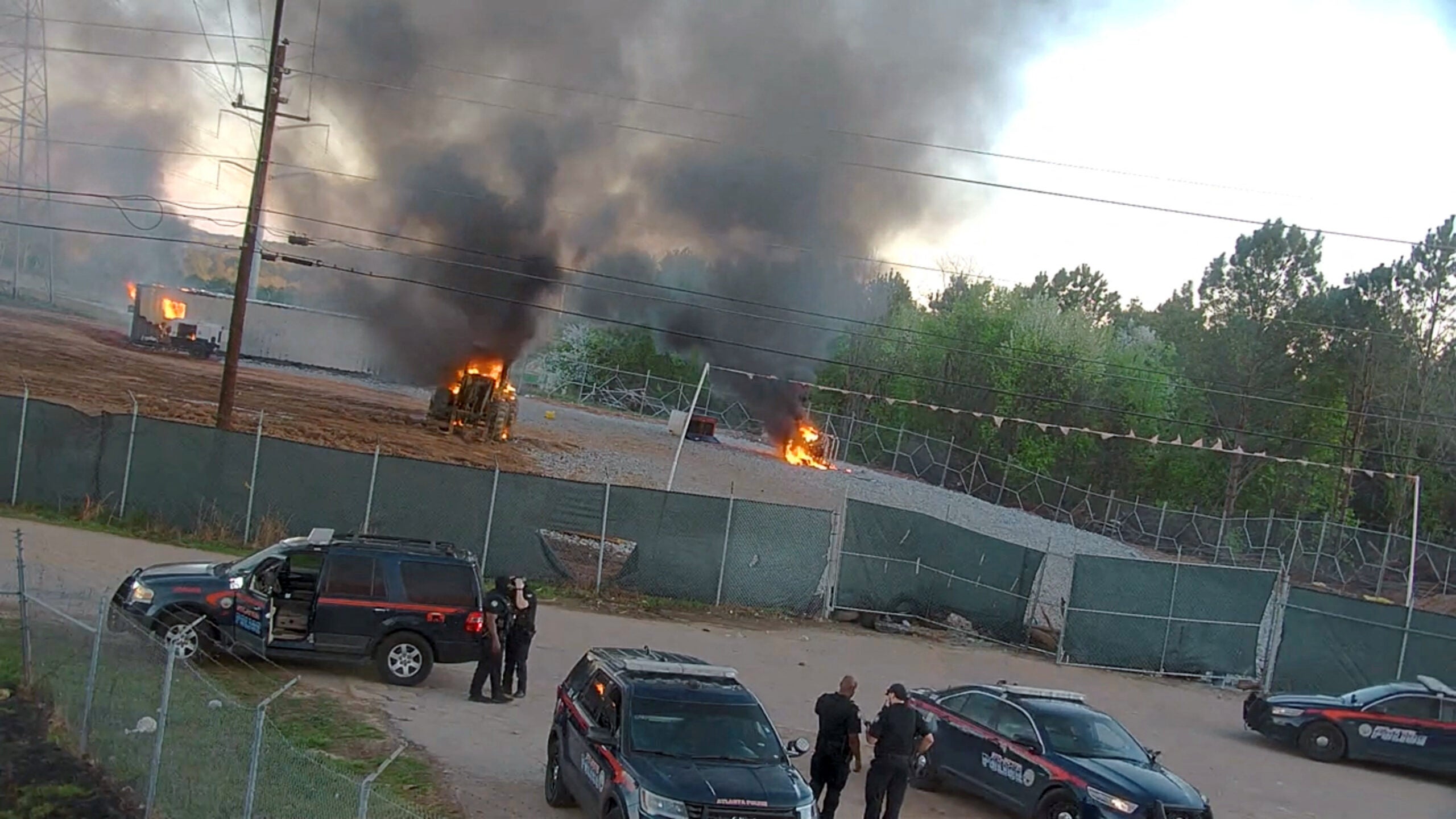 A photo provided by the Atlanta Police Department shows vehicles burning after hundreds of activists breached the site of a proposed police and fire training center in Atlanta's wooded outskirts on Sunday, March 5, 2023, burning police and construction vehicles and a trailer, and setting off fireworks toward officers stationed nearby.