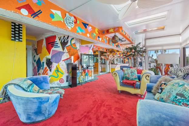 The poolside room has red carpeting and orange walls with 80s deco patterns.