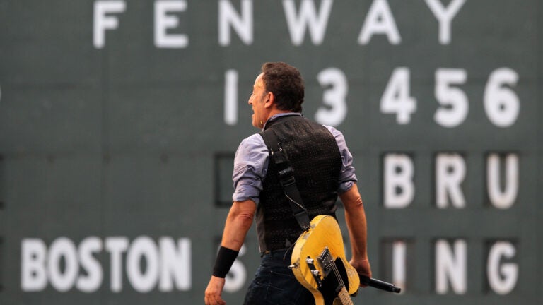 Bruce Springsteen stands in front of the scoreboard at Fenway Park in 2012