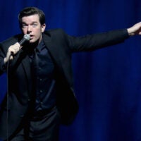 John Mulaney gesticulates while performing comedy.