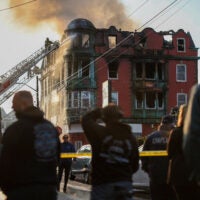 Several people look at the Royal Crown Lodging, a New Bedford rooming house that erupted in flames.