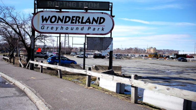 A sign reading "Wonderland Greyhound Park" sits in front of a mostly empty parking lot.