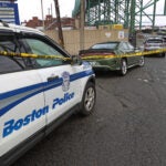 A Boston Police officer tapes off the criem scene under the Tobin Bridge.