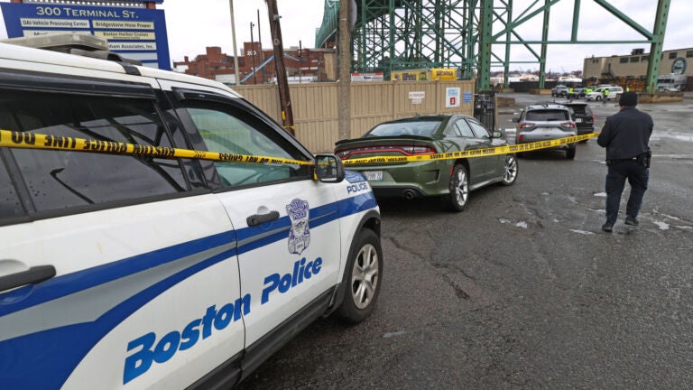 A Boston Police officer tapes off the criem scene under the Tobin Bridge.