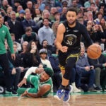Stephen Curry steals the ball from a diving Marcus Smart.