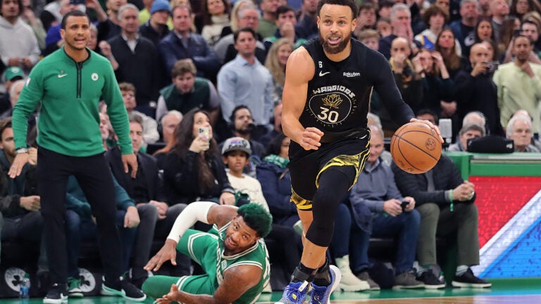 Stephen Curry steals the ball from a diving Marcus Smart.