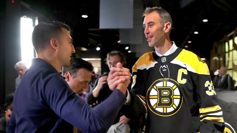 Patrice Bergeron (left) congratulates Bruins Zdeno Chara after Chara held a press conference at TD Garden to announce his retirement after he signed a one-day contract with the team to retire form the Bruins and the NHL.