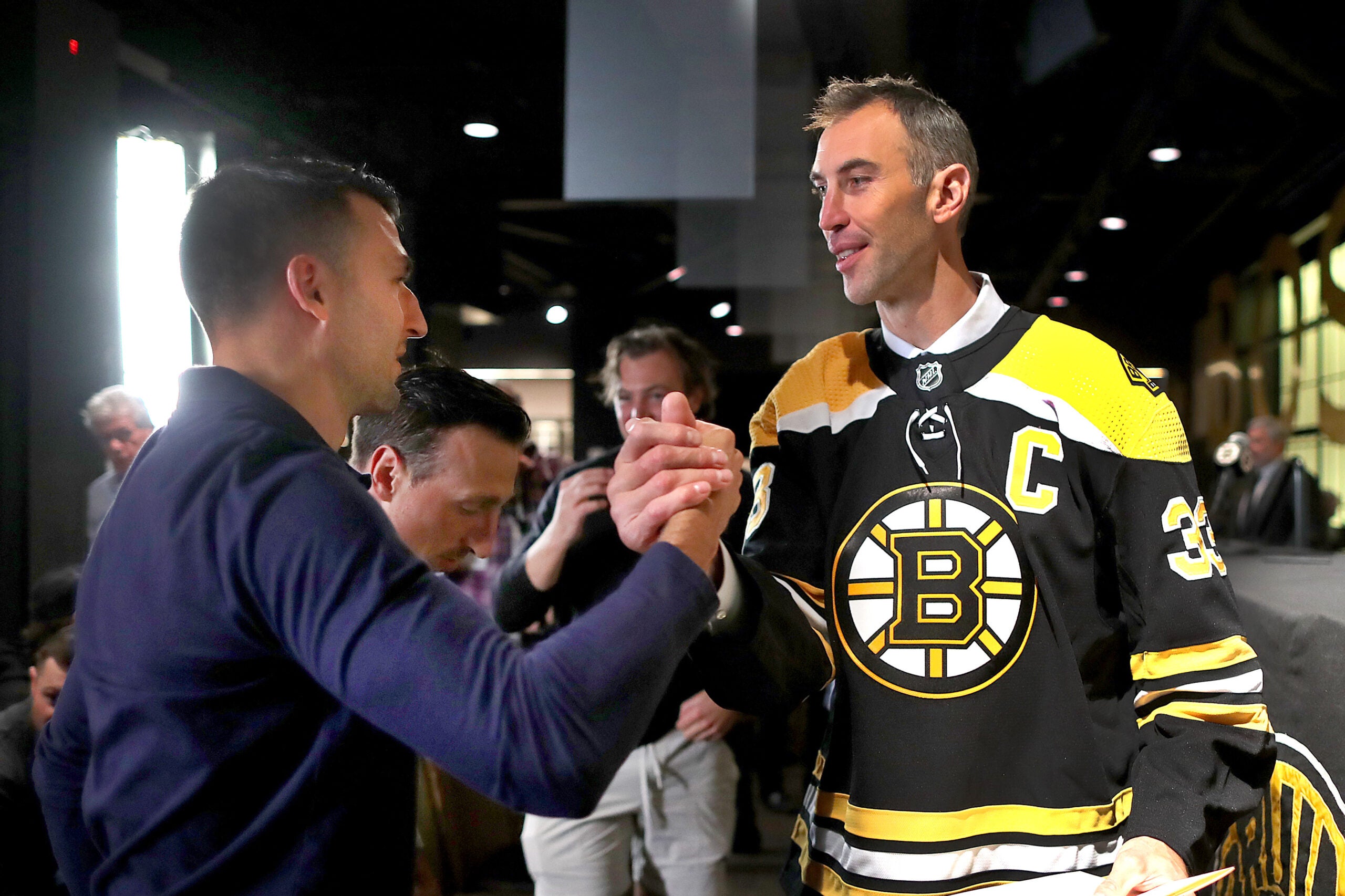 Patrice Bergeron (left) congratulates Bruins Zdeno Chara after Chara held a press conference at TD Garden to announce his retirement after he signed a one-day contract with the team to retire form the Bruins and the NHL.