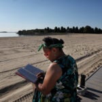 A woman reads at Carson Beach.