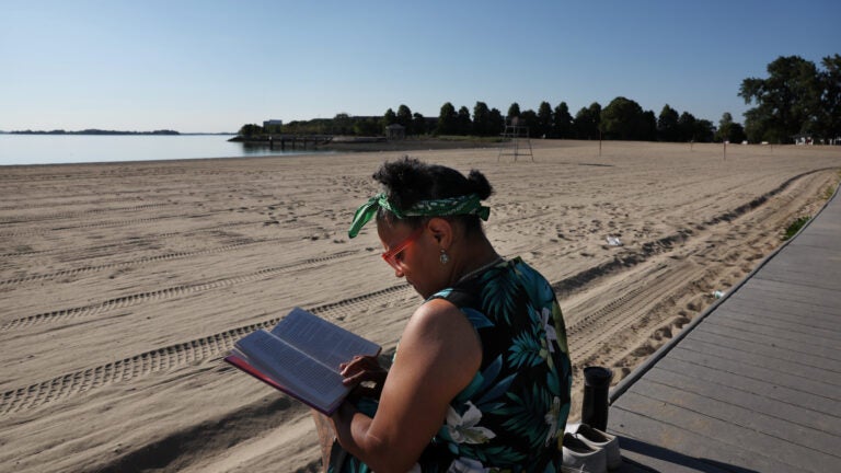 A woman reads at Carson Beach.