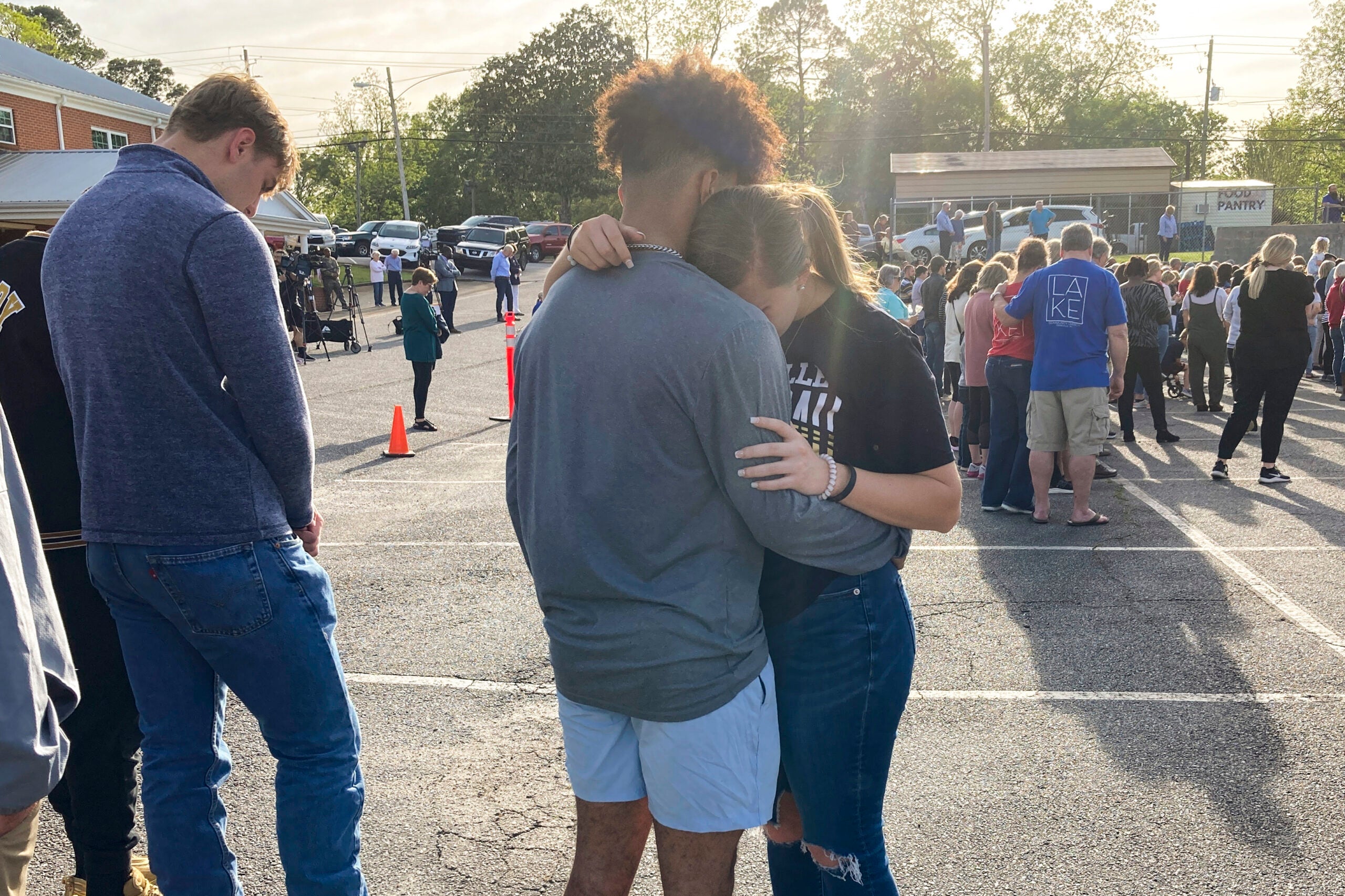 Two teens embrace at a prayer vigil on Sunday, April 16, 2023, outside First Baptist Church in Dadeville, Ala. 